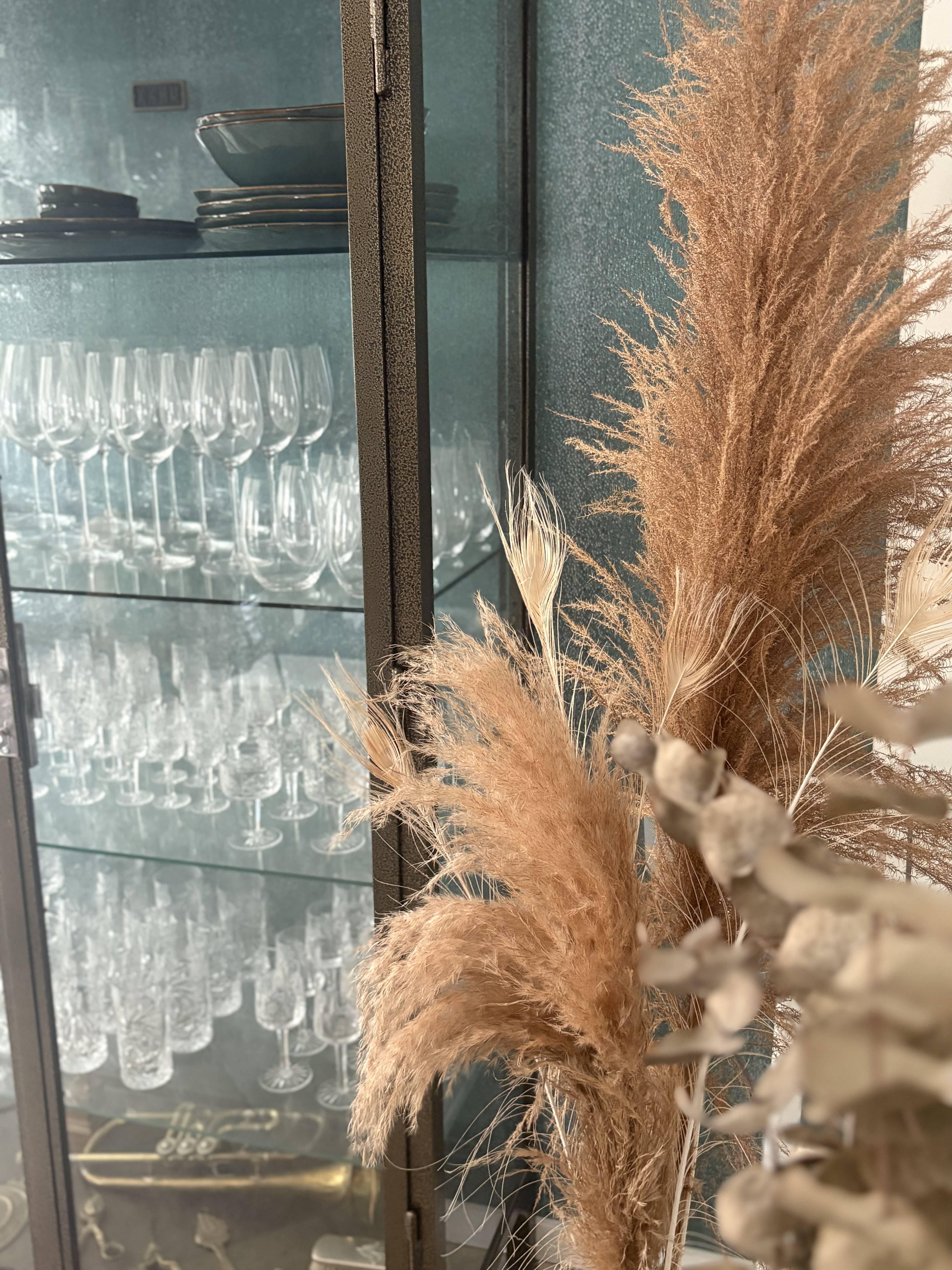 Vitrineskab med blomst i forgrunden